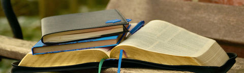Notizbücher und Kugelschreiber auf einer Bibel